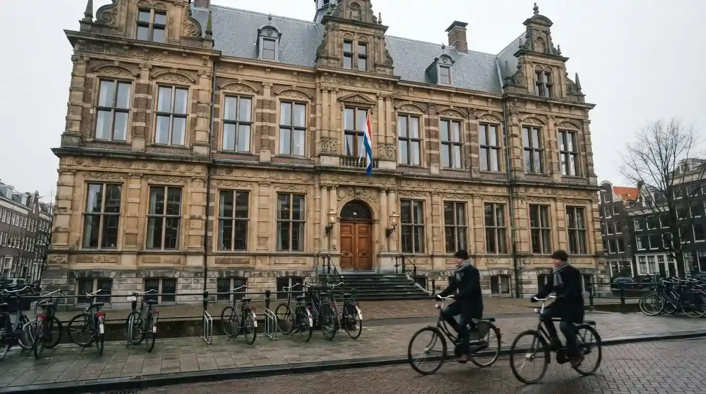 Vooraanzicht van een statig kantoorgebouw in een Nederlandse stad met fietsers die voorbijrijden.